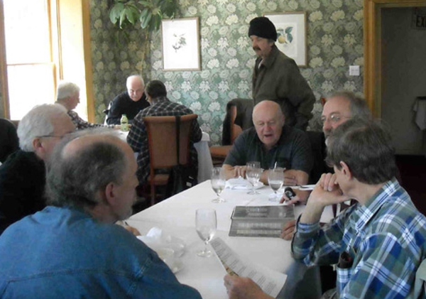 Clockwise around the table: Nick Poppenk (foreground), Bruce Anderson, Jim Carde, Art Kalmes
                    (standing), Arnie Janson, Mirko Zatka