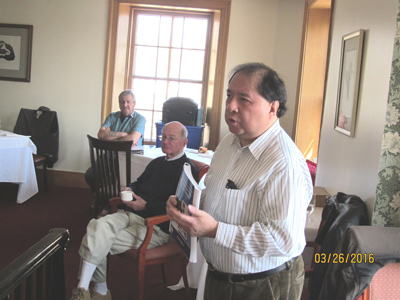 Andrew Chung tells members about his new book.
                Bob Vogel (left) and Derek Smith listen in the background.