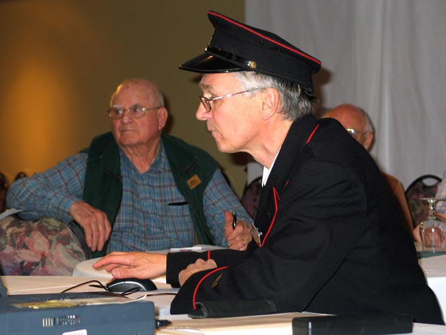 Tracy Cooper in mail clerk regalia with an exhibit of
                advertising covers of Vancouver